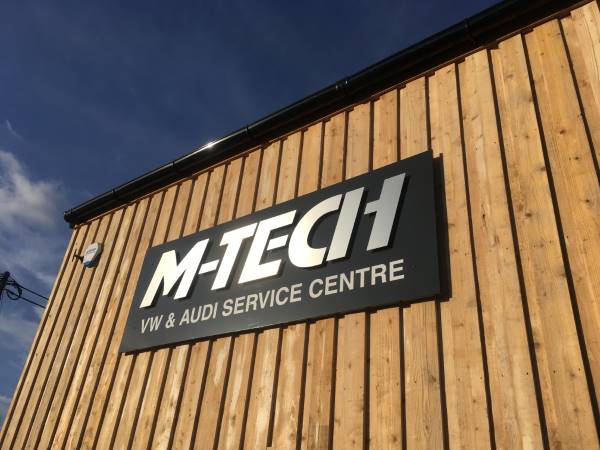 A metallic lettering business sign on a commercial unit